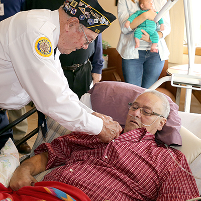 Veteran puts a pin on the shirt of a fellow veteran as part of Beaver Dam Community Hospital's We Honor Veterans Pinning Program